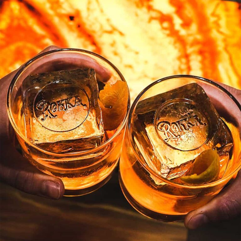 Two whiskey cocktails served over large ice cubes at Rokka
