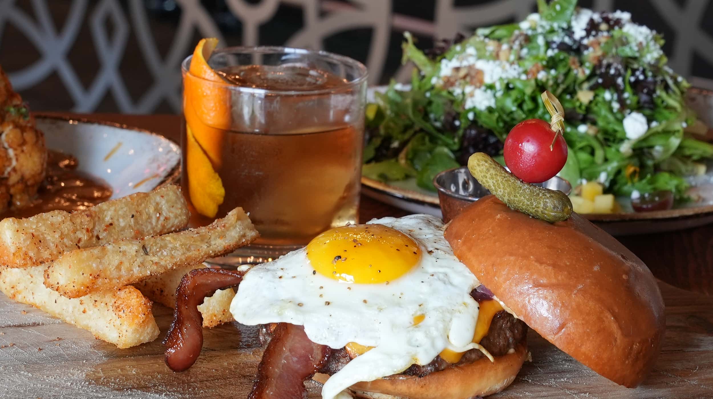 Rokka burger, salad, cauliflower, and crafted cocktail